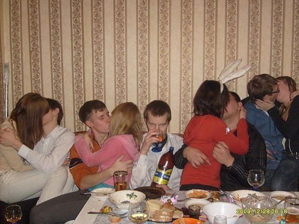 man alone at party, surrounded by kissing couples