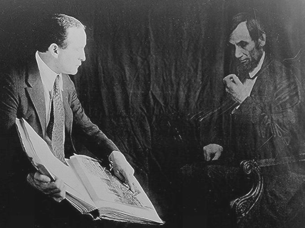 Houdini with a book in front of illisory ghost of Abraham Lincoln